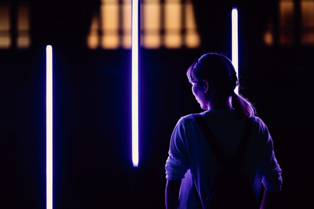 rear-view-woman-standing-against-illuminated-lights-night